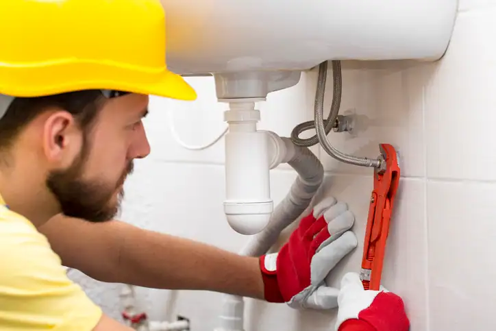 Emergency plumber repairing a leaking pipe in a Natick, MA